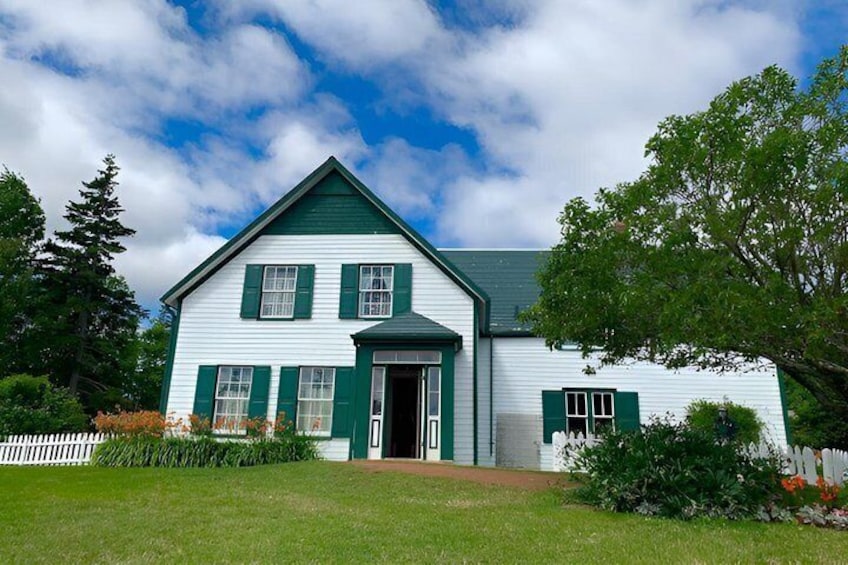 A white house with green shutters and a green roof. 3