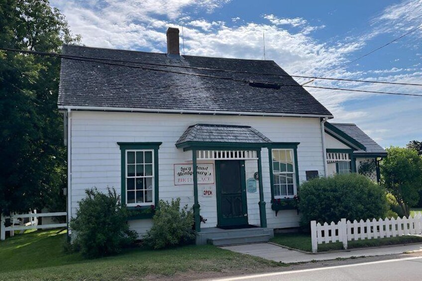 A white building with green trim and a white picket fence. 1