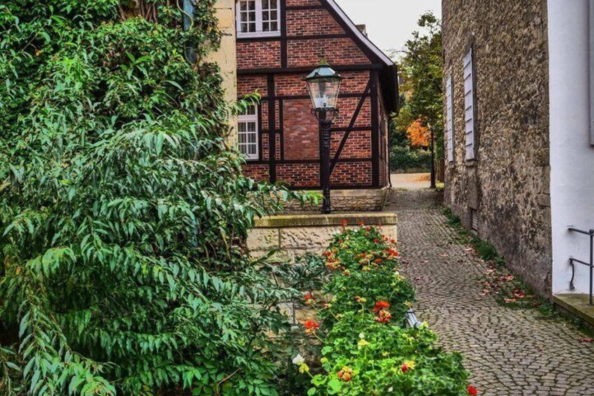 A cobblestone path, a traditional half-timbered house, and lush greenery. 3