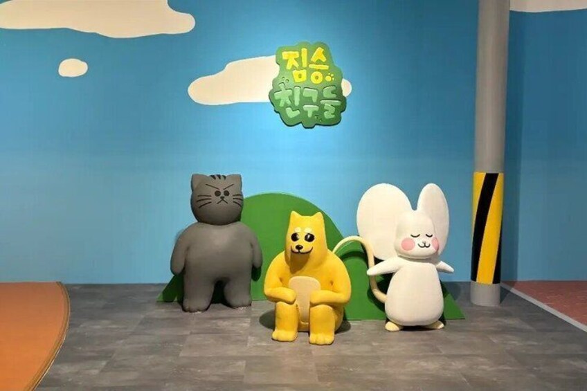 A room with a blue wall, a green plant, and three plush toys: a cat, a dog, and a rabbit. 2