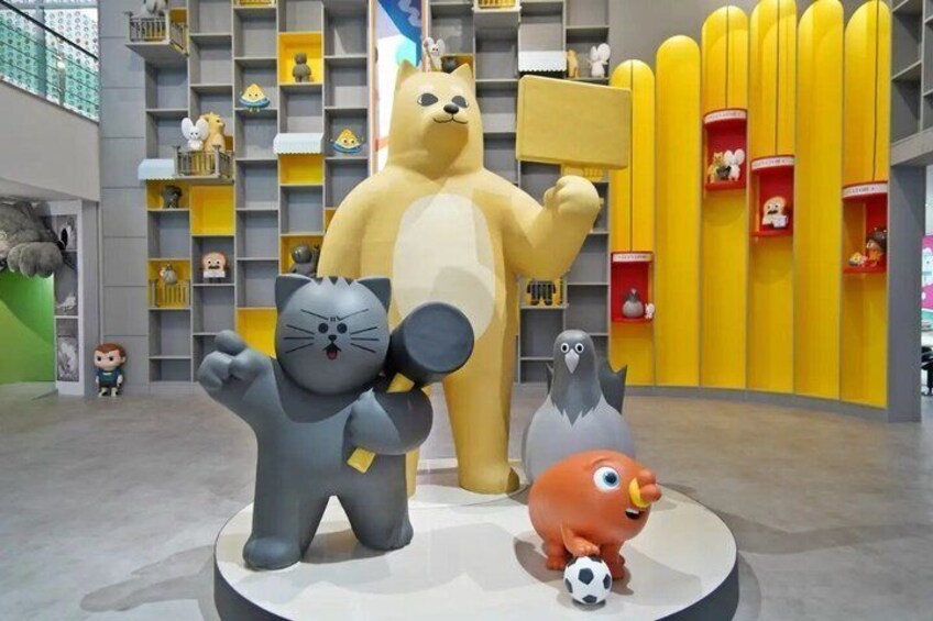 A large cat figurine, a bear, and a penguin in a modern indoor setting with shelves and toys. 1