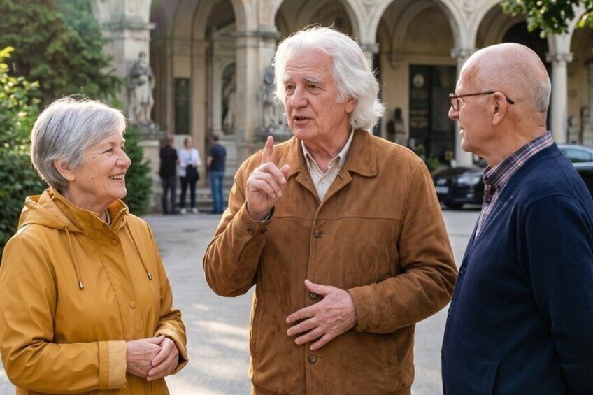 Three people conversing outdoors in a historic building with arches. 3
