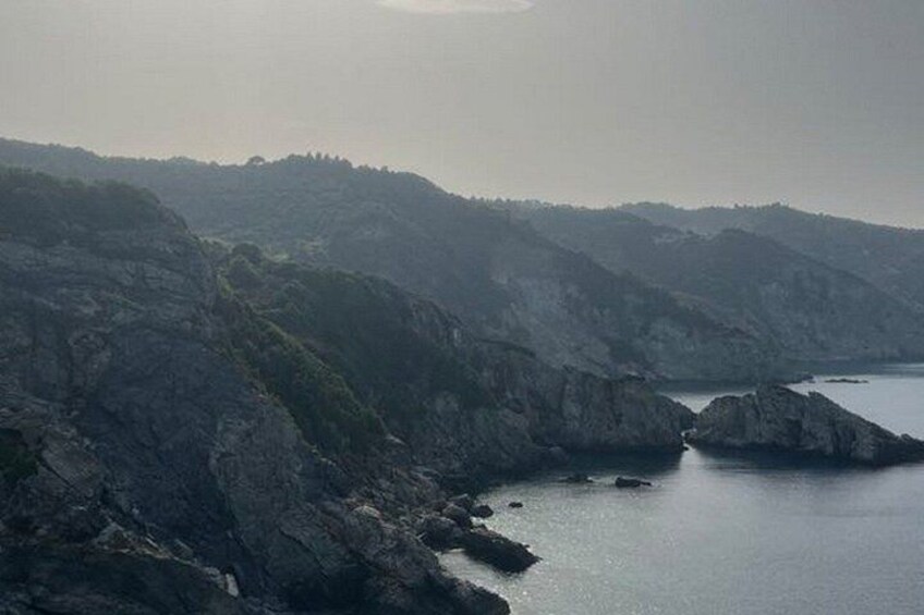 A coastal landscape with rocky cliffs and a calm sea. 4