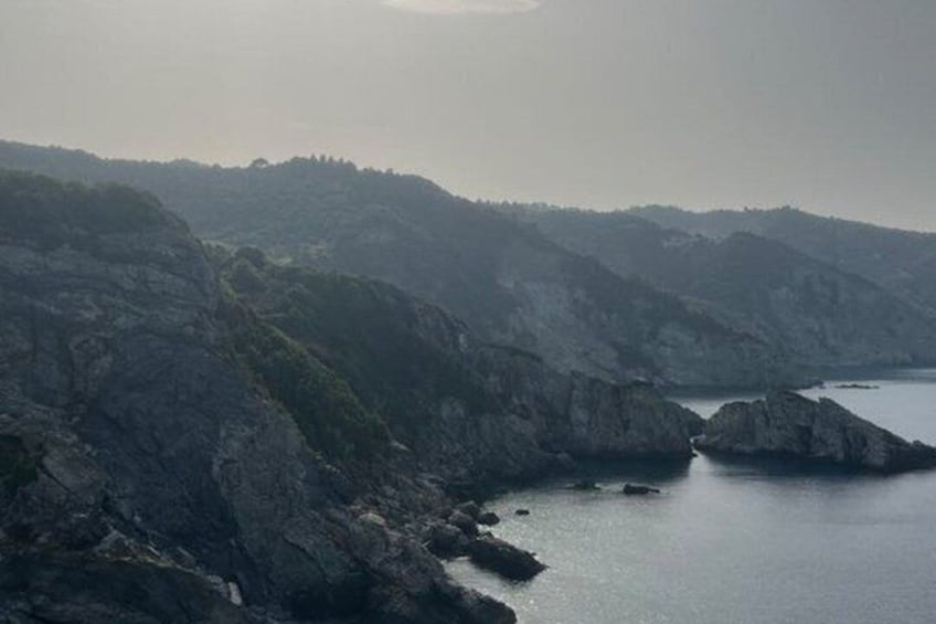 A coastal landscape with rocky cliffs and a calm sea. 4