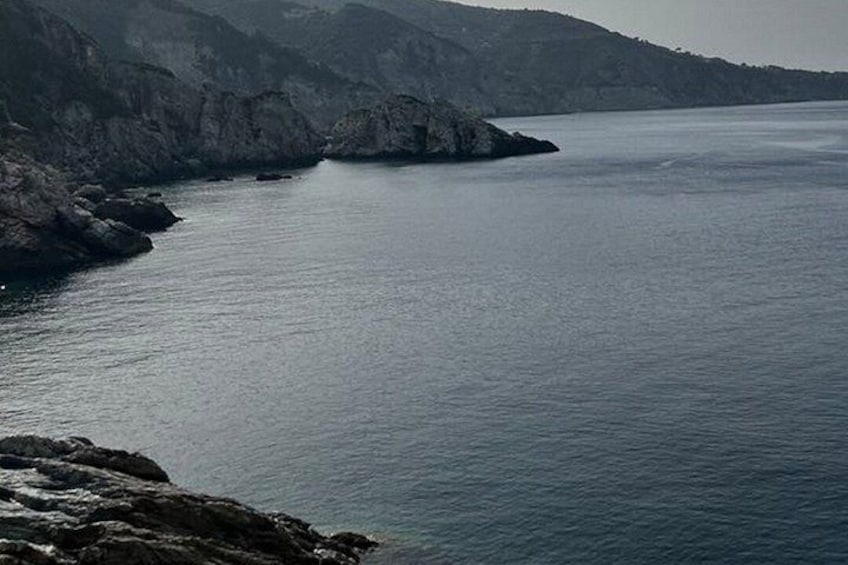 A coastal landscape with rocky cliffs and calm sea. 5
