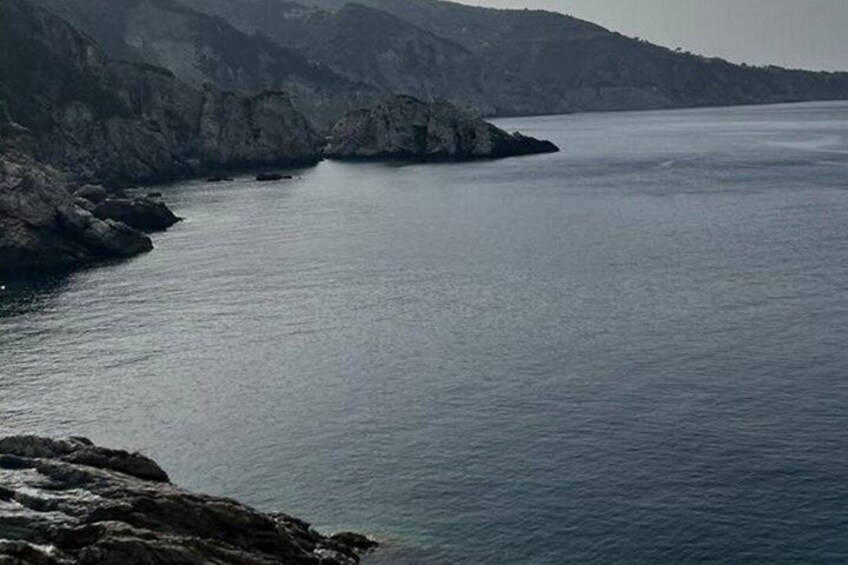 A coastal landscape with rocky cliffs and calm sea. 5