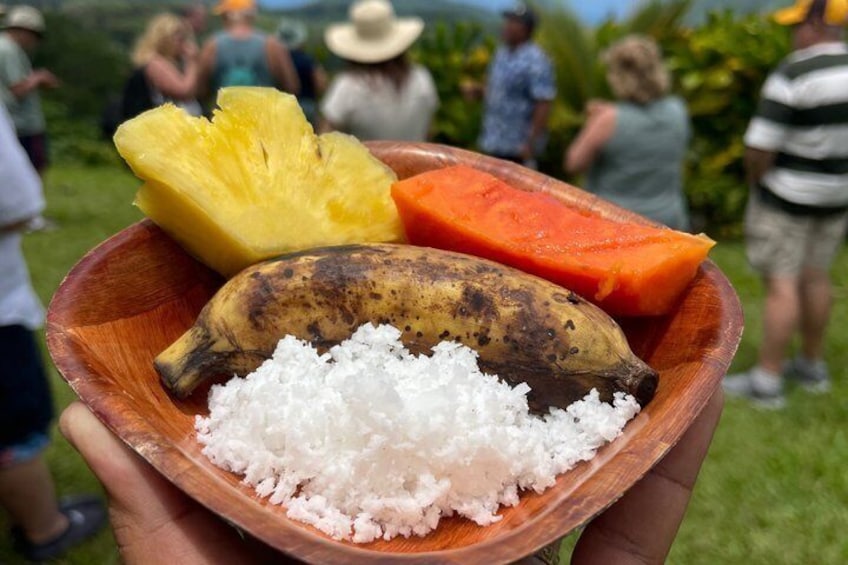 A wooden bowl containing a banana, pineapple, and carrot. 5