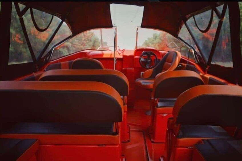 A red vehicle interior with black seats, a steering wheel, and a dashboard. 4