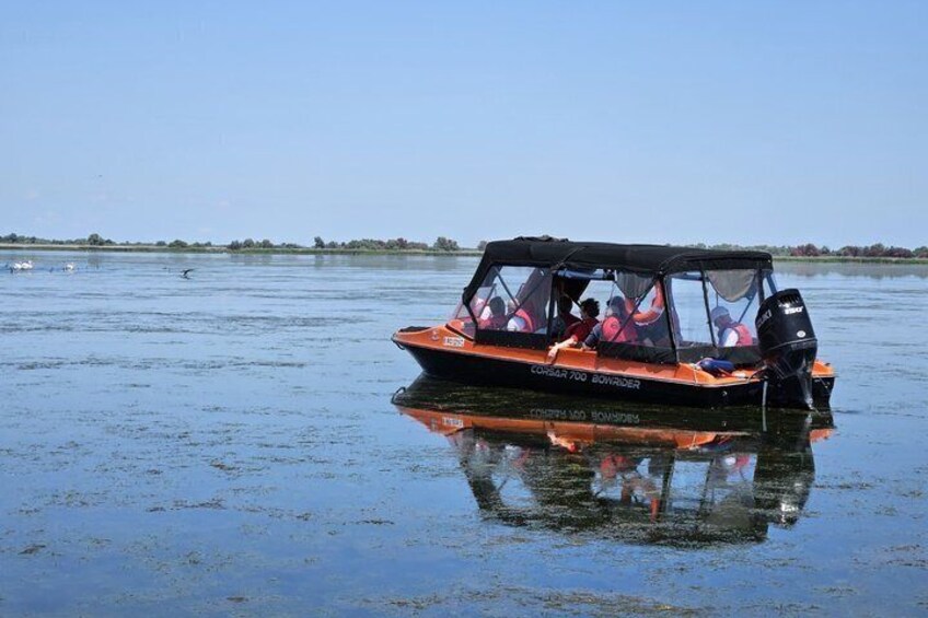 A boat with people on it, floating on calm water. 5
