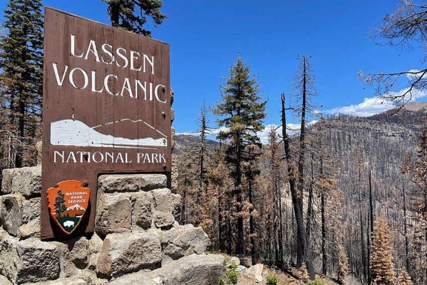 Lassen Volcanic National Park sign with a mountain and park service logo. 1