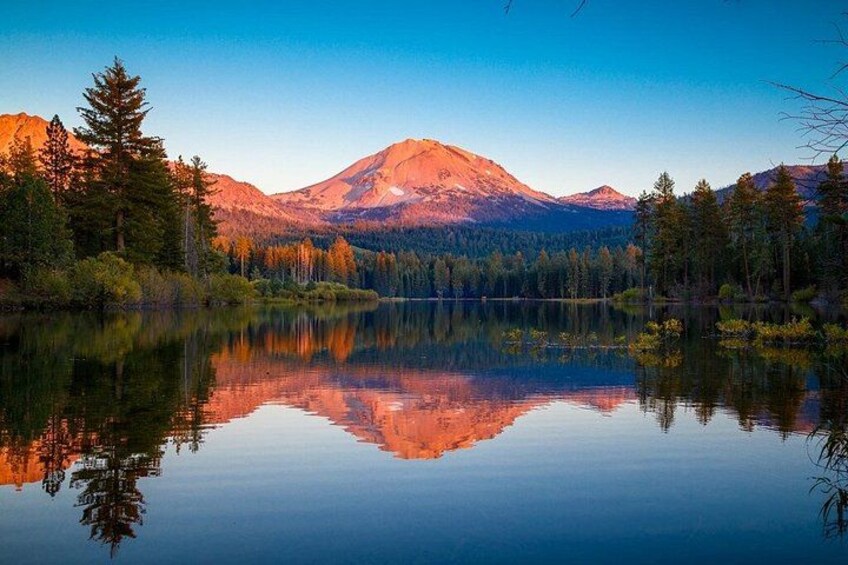 A mountain lake with reflections, surrounded by trees and mountains. 2