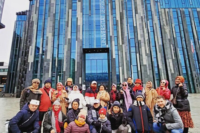 A group of people in front of a modern building with a glass facade and a sign that reads 'UNIVERSITAT VALLS.' 2