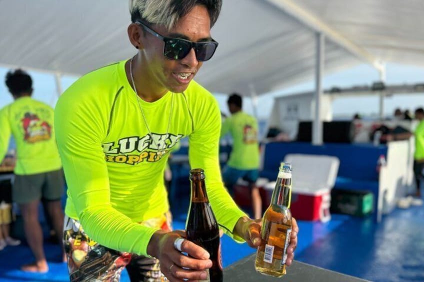A person holding a bottle of beer at a boat event. 5