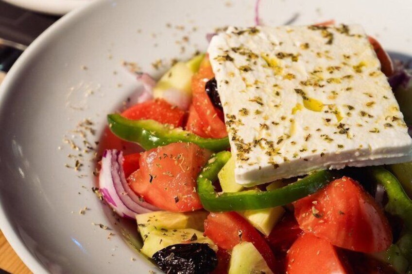 A salad with feta cheese, tomatoes, cucumbers, and red onions. 3