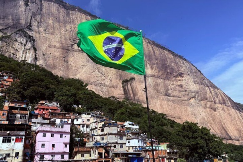 A flag waving in front of a mountain. 1