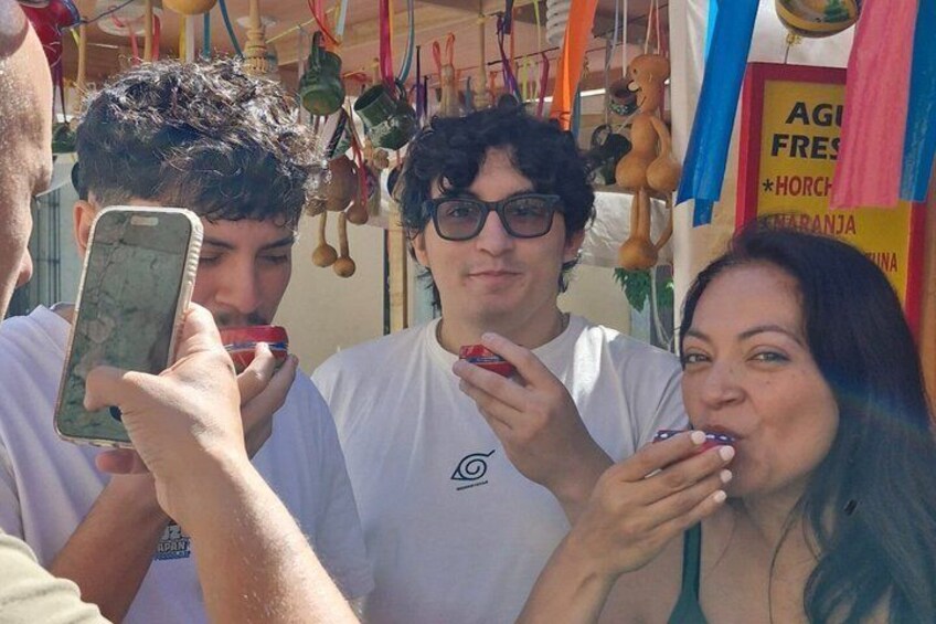 People at a market stall with hanging items. 5
