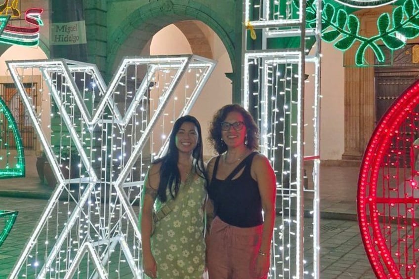 Two people standing in front of illuminated geometric structures. 3