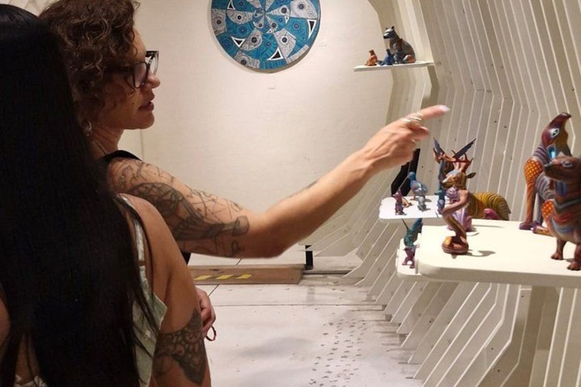 A person pointing at a shelf with figurines. 4