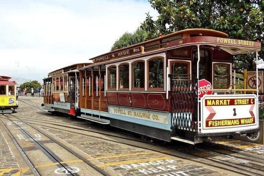 A vintage tram on Powell Street, with 'Powell & Hyde 518' and 'Market Street 1 Fishermans Wharf' signs. 4