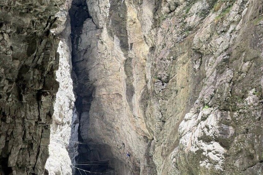 A narrow canyon with steep rock walls and a visible path. 4
