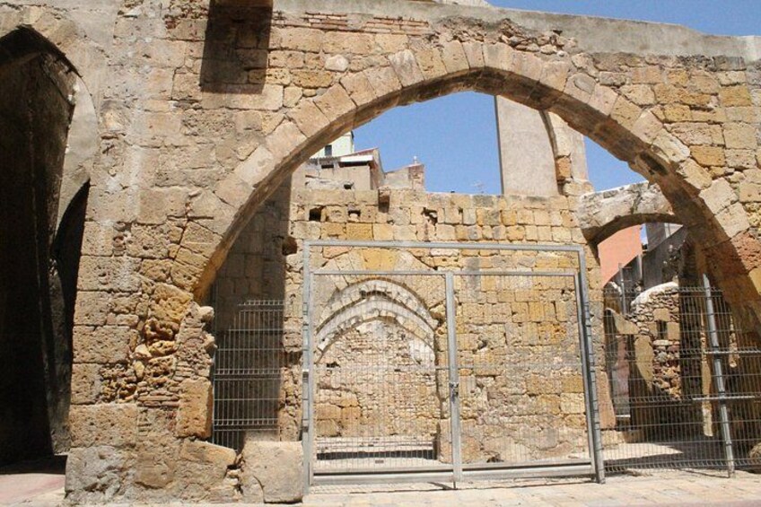 An ancient stone archway with a metal gate, part of a historical structure. 4