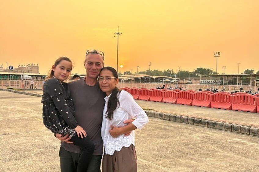 A sunset over a sports field with a group of people standing on a rooftop. 5