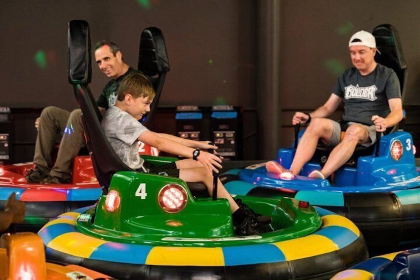 People riding bumper cars in an indoor amusement park. 2