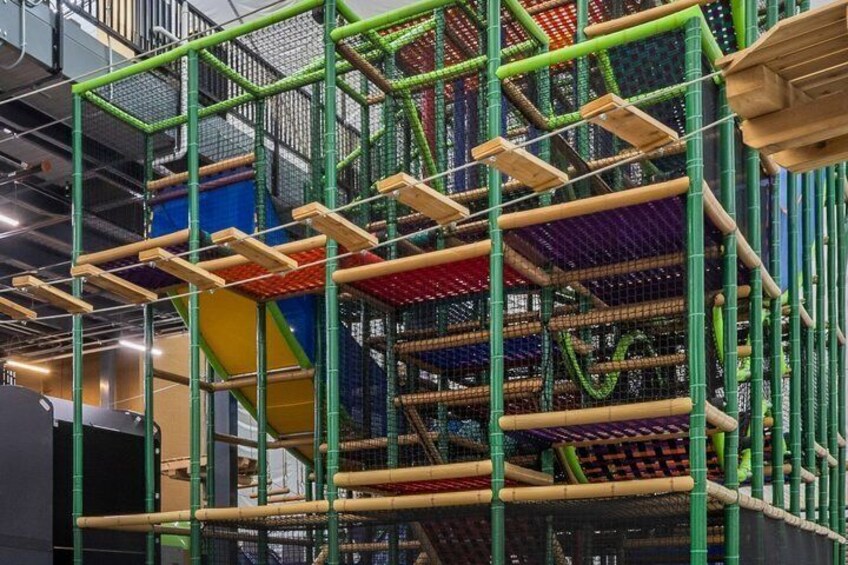 A multi-level indoor play structure with various climbing and sliding elements. 3