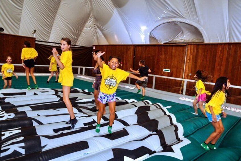 Children in yellow shirts dancing on a stage with a large letter 'A' backdrop. 4