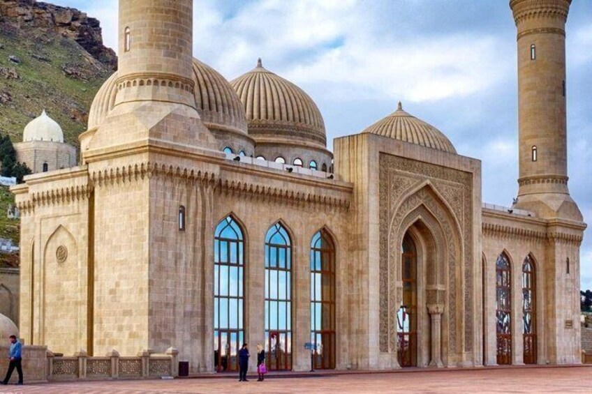 A large mosque with multiple domes and minarets, featuring arched windows and intricate stonework. 1