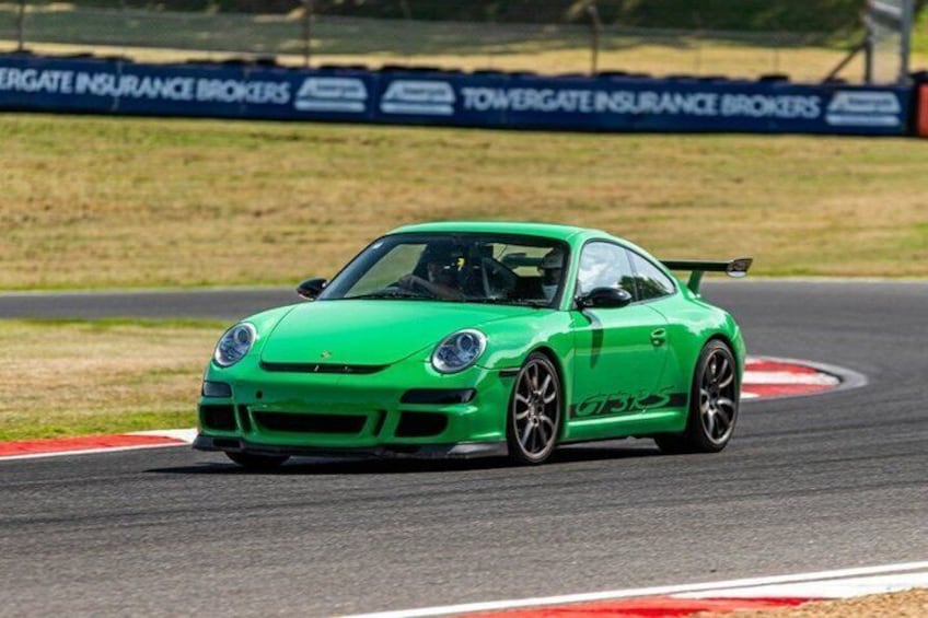 A green sports car on a race track. 1
