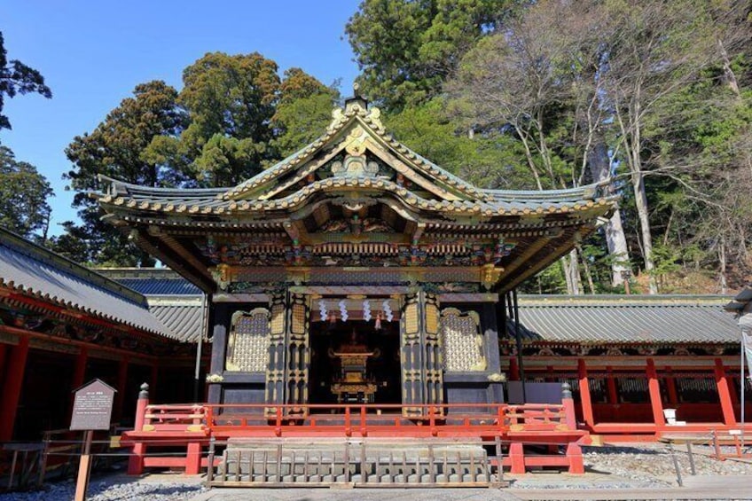 A traditional Japanese temple with ornate architecture, a red torii gate, and a stone lantern. 2