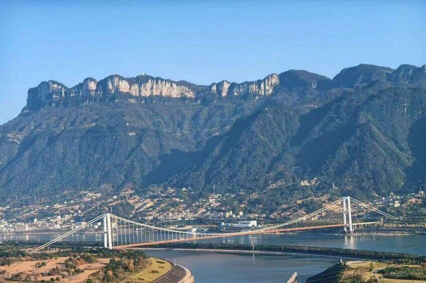 A bridge spanning a river, with mountains in the background. 4