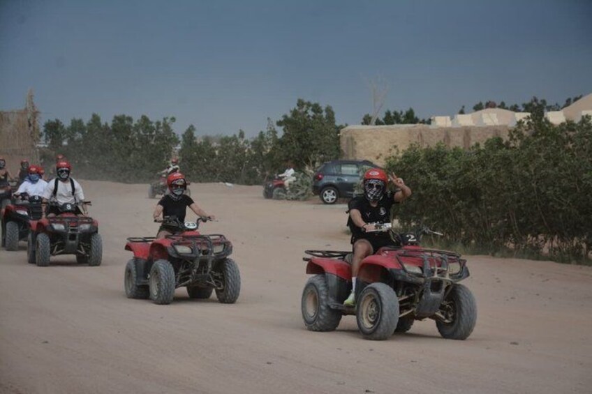 A group of people riding ATVs on a dirt road. 4