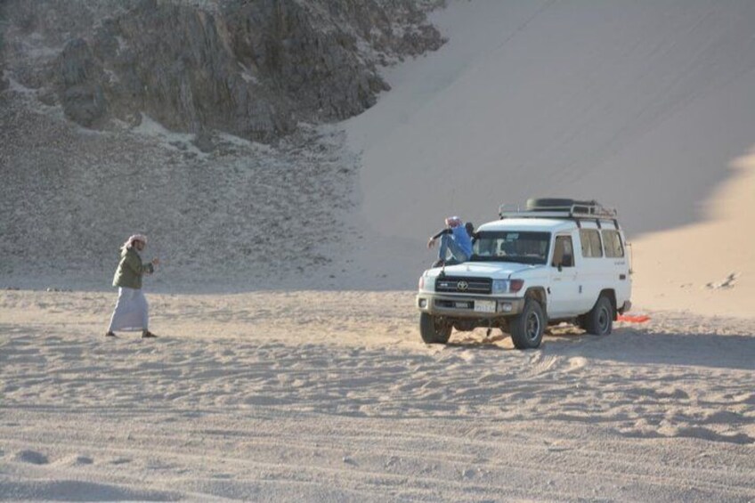 A white vehicle on a snowy landscape with a person in a white skirt and a person in a blue jacket. 5