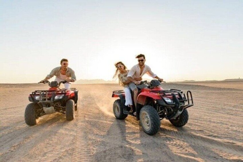 Two people riding ATVs in a desert landscape. 1