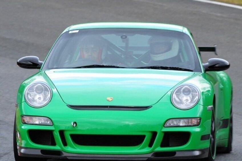 A green sports car on a road. 3