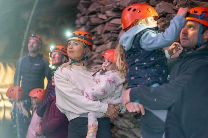 People wearing helmets and holding onto a rope, indicating a climbing or rappelling activity. 3