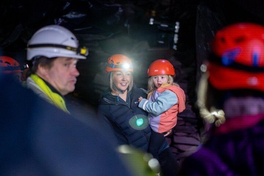 People wearing helmets and headlamps in a cave. 2