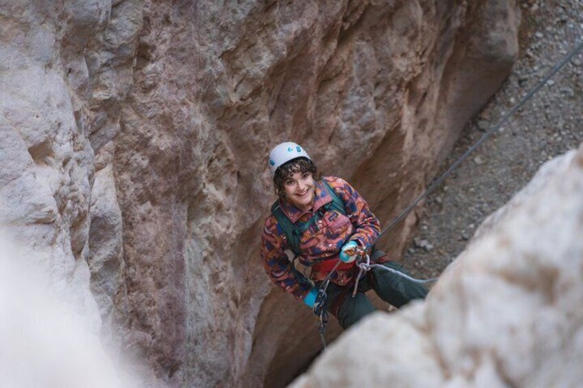 A person rappelling down a rocky cliff. 1