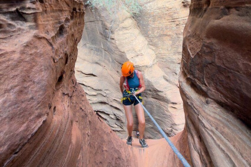 A person rappelling down a canyon wall. 1