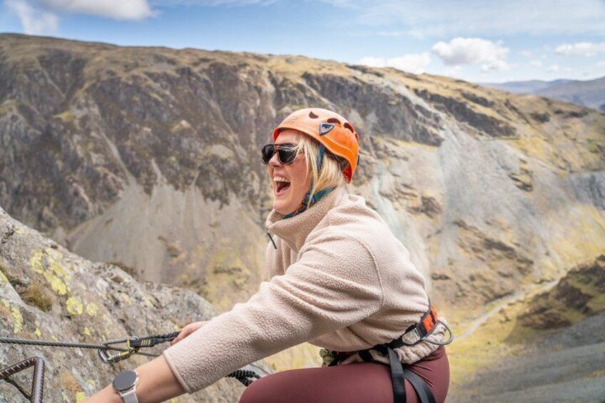 A person on a mountain bike with a helmet, wearing a jacket and gloves, in a rocky mountainous area. 1