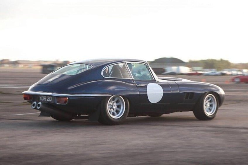 A vintage sports car parked on a racetrack. 3