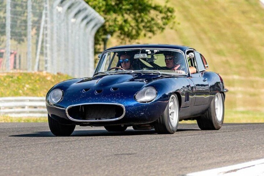 A blue vintage car on a race track. 1