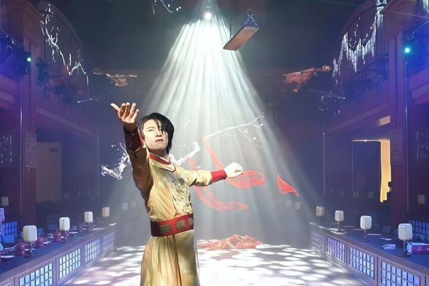 A person in a traditional costume performing in a theater with a spotlight and red stage effects. 3