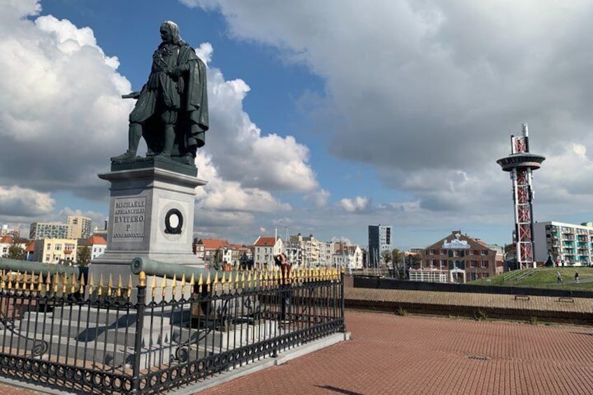 A statue, a tower, and buildings in a cityscape. 3