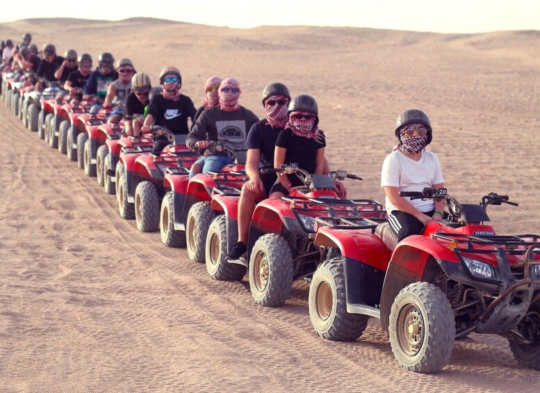 A line of people on ATVs in a desert. 4