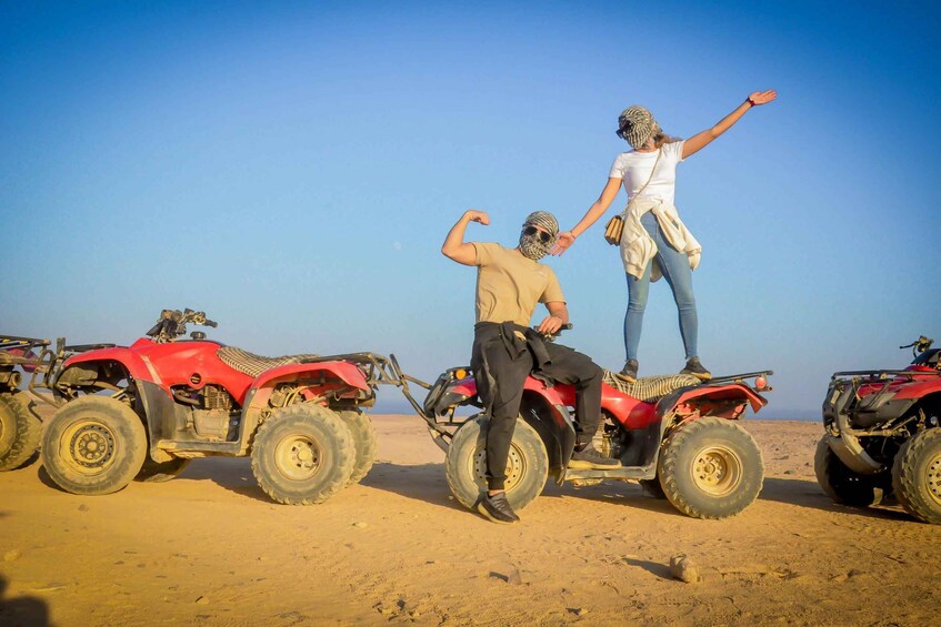 A desert landscape with red off-road vehicles and people. 4