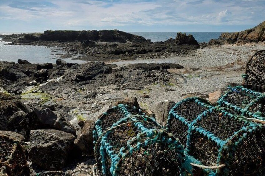 Rocky terrain with fishing nets and a coastal view. 1