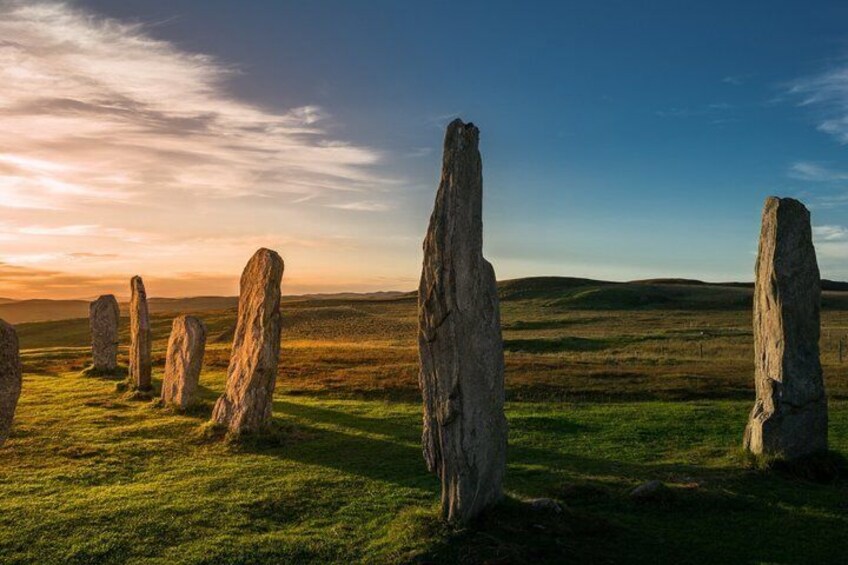 Standing stones in a grassy field with a clear sky. 4